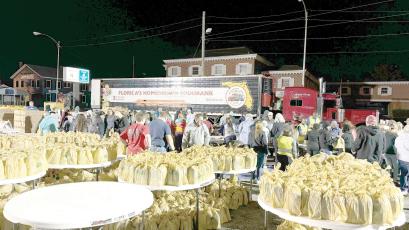 Volunteers help set up for a previous Farm Share food distribution hosted by the Lake City Police Department. A food giveaway is scheduled for Saturday, beginning at 8 a.m. in downtown Lake City. (FILE)