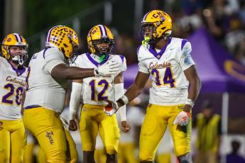 Columbia defensive tackle Jaylen Underwood (8), linebacker Kaleb Williams (12) and defensive end Mikel Morgan (34) celebrate after a play against Trinity Christian last Friday. (GARY LLOYD MCCULLOUGH/Special to the Reporter)