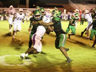 Suwannee safety Josh Johnson (right) and linebacker Marco Rojas wrap up Gainesville running back Javaris Gardner for a loss Friday night. (PAUL BUCHANAN/Lake City Reporter)