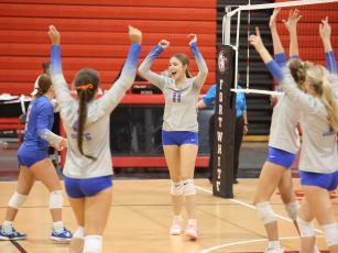 Branford hitter Paisley Knight (11) and the Buccaneers celebrate after a point against Fort White on Tuesday. (PAUL BUCHANAN/Lake City Reporter)