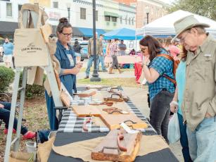 Woodwork from ‘Them Boards’ is viewed by some shoppers at a previous Lake City Growers and Makers Market. (COURTESY)