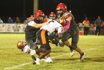 Lafayette linebacker Trevor Byrd tackles Trenton running back Kevone Markham as defensive back Jackson Lawson rushes in on Oct. 16. (PAUL BUCHANAN/Lake City Reporter)