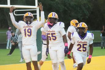 Columbia receiver Legend Camiel (19) celebrates one of his two touchdowns alongside offensive lineman Jiaun Wilson (55) and running back Jerome Horne (25) during last Friday’s win over Ed White. (JORDAN KROEGER/Lake City Reporter)