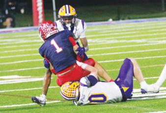 Columbia defensive back Mekah Combs-Turner (back) and linebacker Bryson Grinstead (bottom) combine to tackle Manatee receiver Deno Dalacas on Oct. 2. (JORDAN KROEGER/Lake City Reporter)