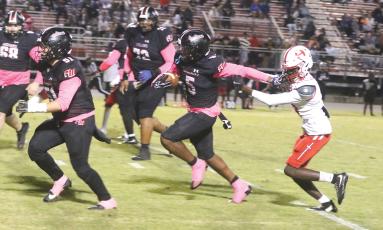 Fort White receiver Brandon Robinson stiff-arms Hamilton County defensive back Avrin Johnson on his way to a 35-yard touchdown in Friday’s 41-0 win. (MORGAN MCMULLEN/Lake City Reporter)
