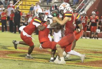 Fort White receiver Jakori Johnson gets tackled by a host of Baker County defenders following a catch on Friday. (MORGAN MCMULLEN/Lake City Reporter)