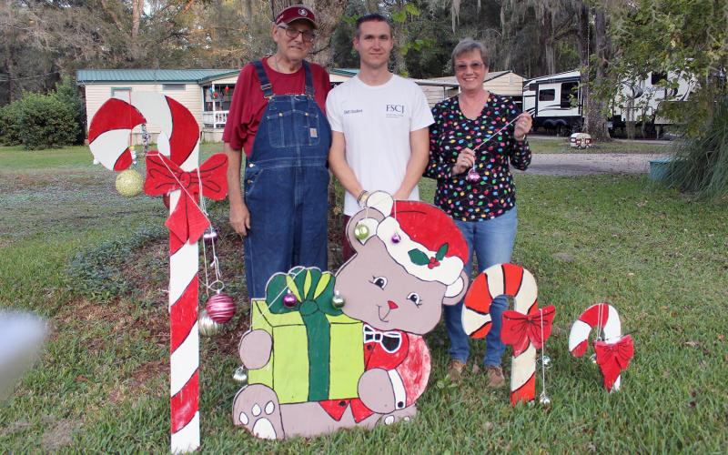 Callahan’s Fred Heinrich, son William Heinrich, Jr. and fiancée Cheryl Hodge stand near one of the themed creations that are on display in their yard on Old Dixie Highway in Callahan.