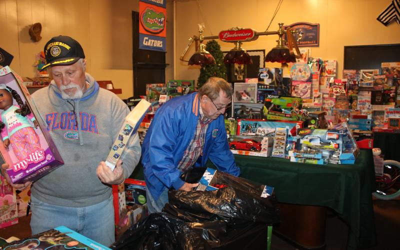 Lake City Elk Club 893 members Michael Lydick (left) and Larry Ward work on arranging toys Thursday afternoon as they prepare for the annual Elks Club Children’s Christmas Party, which will take place at about 5 p.m. on Christmas Eve. (TONY BRITT/Lake City Reporter)
