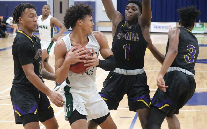 Columbia guard Jordan Smith (0) and forward Marcus Peterson (1) surround Evans’ guard Deshaun Osborne during Monday’s game at the Hitchcock’s Challenge. (JORDAN KROEGER/Lake City Reporter)