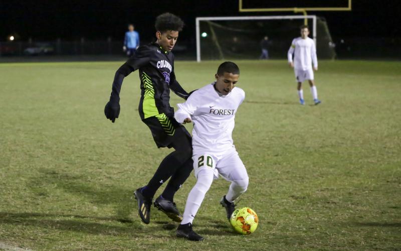 Columbia’s Ismael Cisse chases down possession from Forest’s Gavin Palawski on Tuesday night. (BRENT KUYKENDALL/Lake City Reporter)