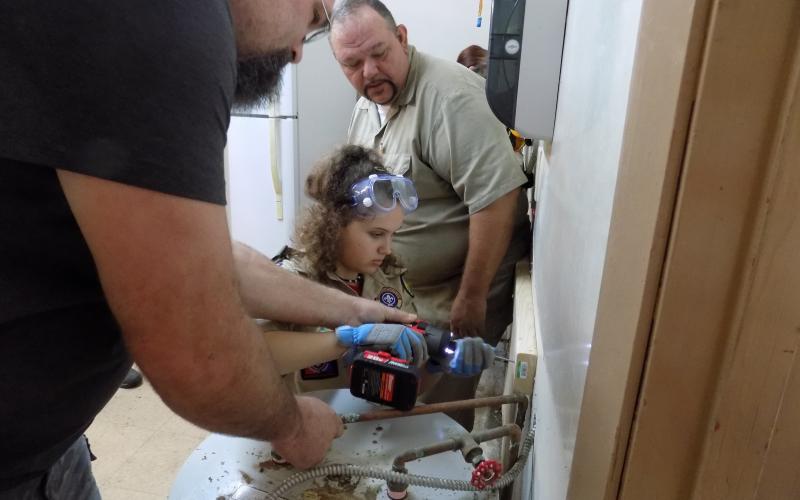 Jayson Wolff helps Skylar Beichner guide in a screw for a shelf as Tom Mullers, the scout master for Troop 85, the boys’ troop, looks on. Under rules put into effect last year, girls can form their own troops in the Boy Scouts, now known as BSA. (STEPHANIE CHAMBERS-WOLFF/Special to the Reporter)
