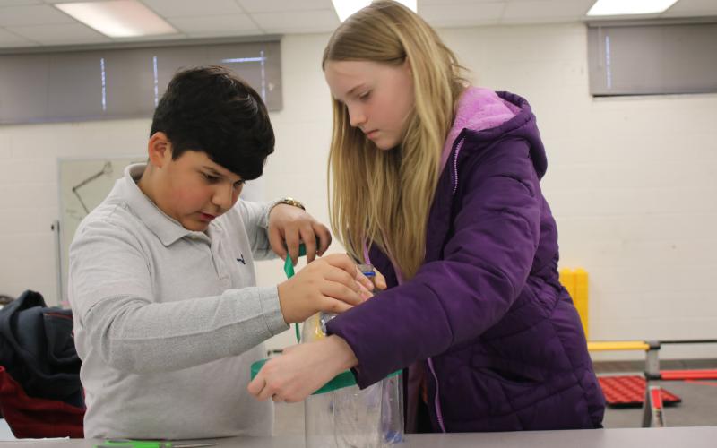 Juan Bustamante (left) and Azlynne Williams prepare for the presentation portion of a robotics competition. TONY BRITT/Lake City Reporter