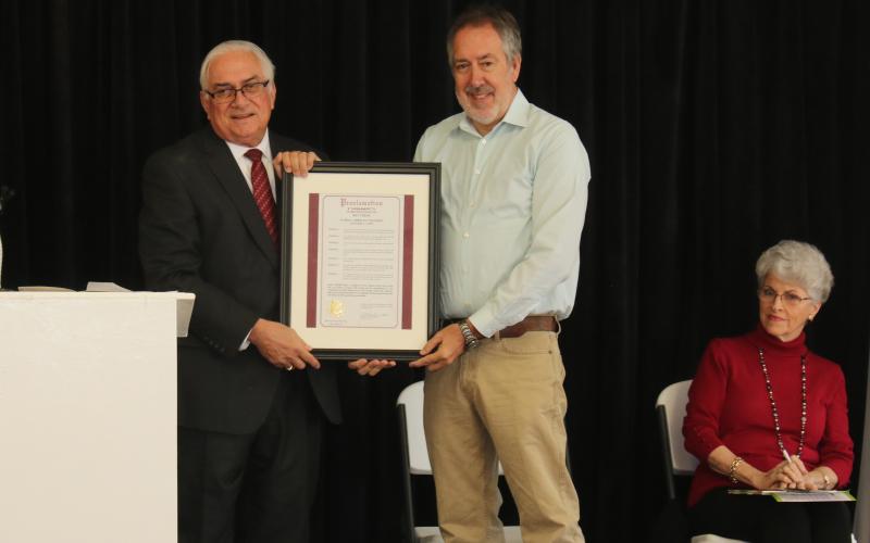 Mayor Stephen Witt presents Kevin Cheek with a copy of the proclamation honoring him on Arbor Day for his efforts beautifying Columbia County. (MICHAEL PHILIPS/Lake City Reporter)