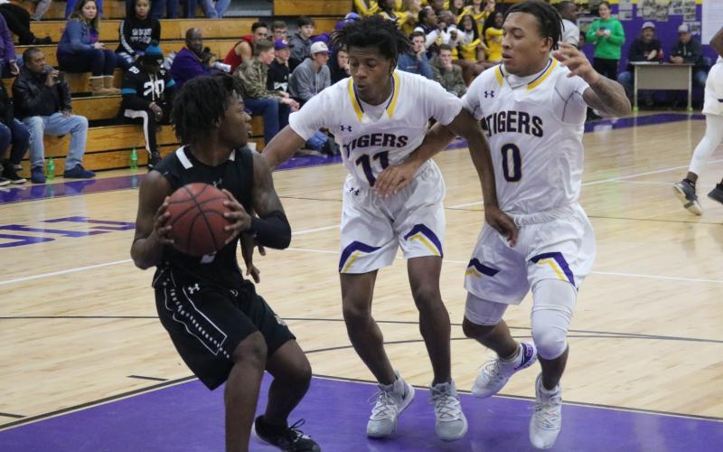 Columbia guards Dante Brown (11) and Jordan Smith (0) pressure Buchholz in the back court during Tuesday night’s game. (JORDAN KROEGER/Lake City Reporter)