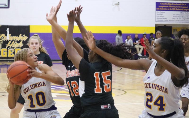 Columbia guard Taylor Ivery is swarmed by Hawthorne defenders during Thursday night’s game. (ZACH ABOLVERDI/Lake City Reporter)