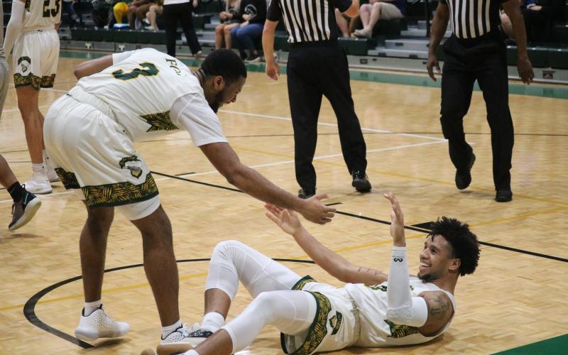FGC guard Kenny Brown celebrates with Diamond Smith after Smith’s dunk against Trinity Baptist College on Thursday night. (JORDAN KROEGER/Lake City Reporter)