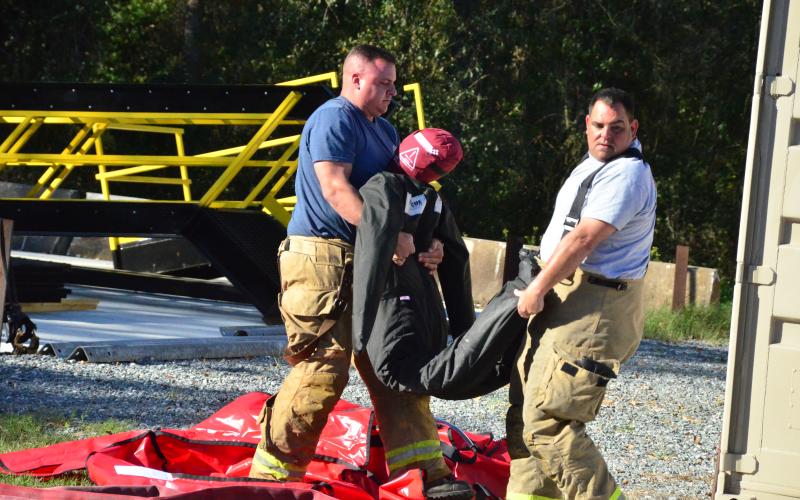 Firefighters lug a search-and-rescue dummy. Friday’s drills marked the end of a week-long gauntlet of training exercises, the first time CCFR has hosted personnel from agencies outside the county. (CARL MCKINNEY/Lake City Reporter)