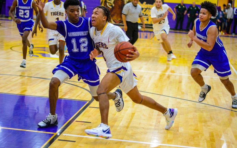 Columbia guard Jordan Smith drives to the basket against Gainesville’s Alex McCray on Tuesday night. (THOMAS RICKS/Special to the Reporter)
