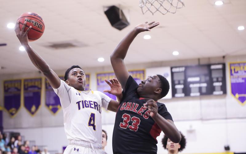 Columbia guard Kenney Gaines gets past Chiles forward Burl Gaskins for a layup during Thursday's Region 1-6A quarterfinal. (BRENT KUYKENDALL/Lake City Reporter)