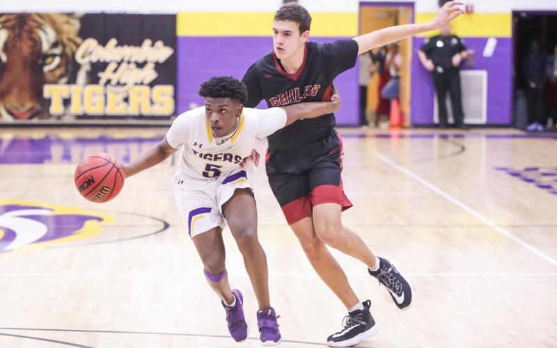 Columbia guard Darrien Jones drives by Chiles froward Sam Hartmann during Thursday's Region 1-6A quarterfinal. (BRENT KUYKENDALL/Lake City Reporter)