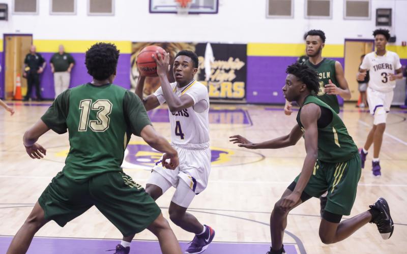 Columbia guard Kenney Gaines looks to pass as Lincoln’s defenses closes in during Tuesday’s Region 1-6A semifinal. (BRENT KUYKENDALL/Lake City Reporter)