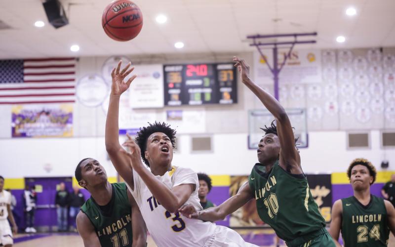 Columbia forward Charleston Ponds puts up a shot between Lincoln's Perry Fisher (11) and Jordan Wilford (10) during Tuesday night's Region 1-6A semifinal. (BRENT KUYKENDALL/Lake City Reporter)