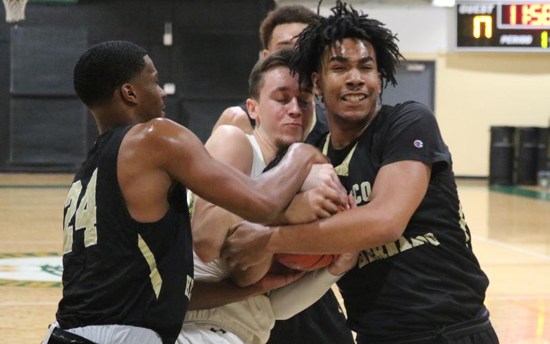 FGC forward Layton Veon battles for a rebound with Pasco-Hernando's Christian Anderson (24) and Warren Mclymont (30) on Saturday. (JORDAN KROEGER/Lake City Reporter)