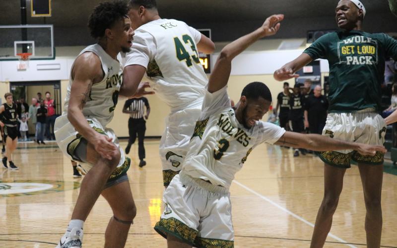 FGC players Diamond Smith (0), Kenny Brown Jr. (3), Jarrett Gardner (43) and Jeremiah Tisme (right) celebrate after defeating Pasco-Hernando State College in the Divison II Region 8 championship on Saturday. (JORDAN KROEGER/Lake City Reporter)