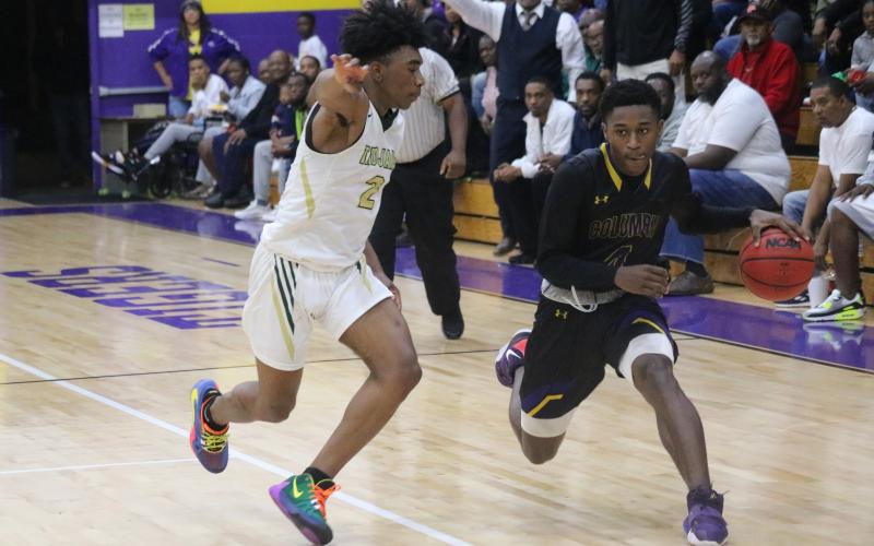 Columbia guard Kenney Gaines drives as Lincoln guard Zae Wiggins on Saturday night.  (JORDAN KROEGER/Lake City Reporter)