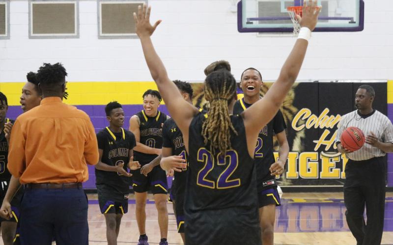 Columbia forward Fonsa Bryant raises his arms in the celebration as forward D'Andre Jefferson walks towards him with a smile following their team's win over Lincoln for the District 2-6A title Saturday night.  (JORDAN KROEGER/Lake City Reporter)