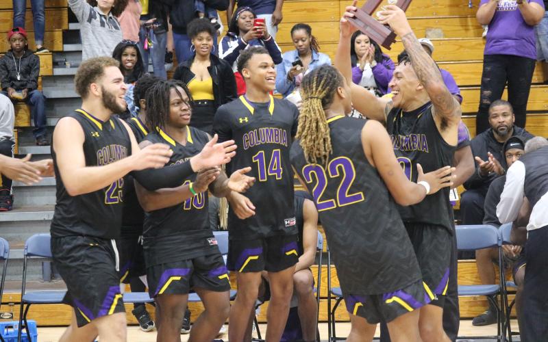 Columbia's basketball team celebrates after defeating Lincoln to win the District 2-6A title on Saturday night.  (JORDAN KROEGER/Lake City Reporter)