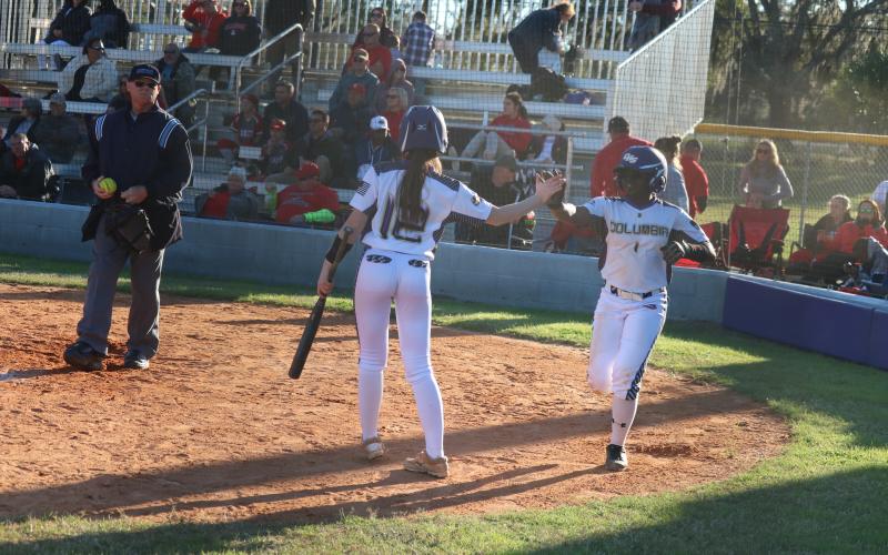 Columbia’s Anissa Penniman (12) high fives Zoryana Hughes after Hughes scored the game-winning run on a passed ball against Lafayette on Friday. (JORDAN KROEGER/Lake City Reporter)