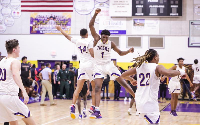Columbia forward Marcus Peterson (1) celebrates with guard Amare Ferrell (14) after the Tigers beat Daytona Beach Mainland in last Friday’s Region 1-6A final. (BRENT KUYKENDALL/Lake City Reporter)