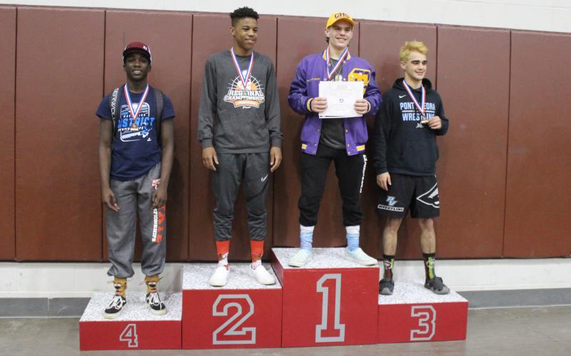 Columbia wrestler Alex McGuigan on the medal stand after winning the Region 1-2A title in the 138-pound weight class on Saturday. (COURTESY)