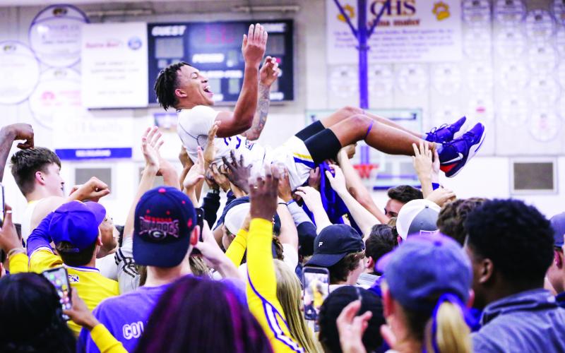 Columbia guard Jordan Smith is lifted up by students and teammates after the Tigers defeated Daytona Beach Mainland 70-65 in last Friday's Region 1-6A final. (BRENT KUYKENDALL/Lake City Reporter)