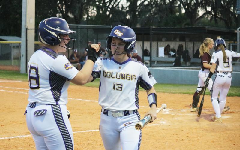 Columbia catcher Reece Chasteen celebrates with third baseman Morgan Hoyle after Hoyle scores in the first inning against Madison County on Thursday night. (JORDAN KROEGER/Lake City Reporter)