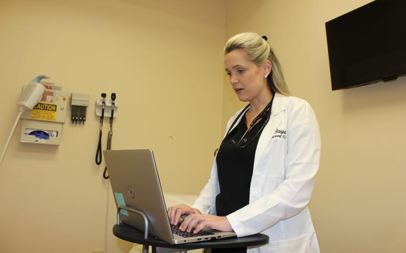 Lyndsey Jones, APRN at Baya Urgent Care in Lake City, speaks with a patient via a TeleMedicine video call Tuesday afternoon. The company launched the video chat service to ease patients’  fears over COVID-19 and give them a safe option for treatment without being exposed to others in waiting rooms at clinics and doctor’s offices.                   The service also provides a safe option for a question screening for people who fear they may have the COVID-19 coronavirus. (TODD WILSON/Lake City Reporter)