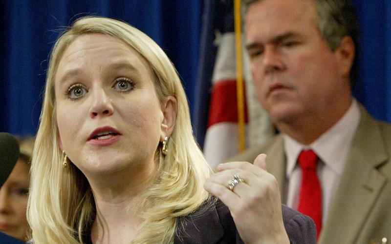 AP PHOTO In this 2004 photo, Tiffany Carr, executive director of Florida Coalition Against Domestic Violence, is seen with Gov. Jeb Bush, background right. (AP FILE PHOTO)