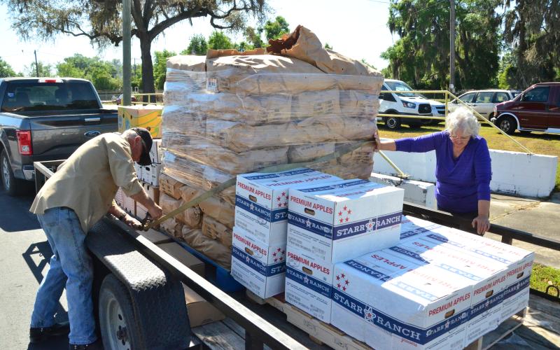 Sam and Karen Bass from Live Oak Church of Christ Central load up on goods for their church’s pantry on Friday. (CARL MCKINNEY/Lake City Reporter)