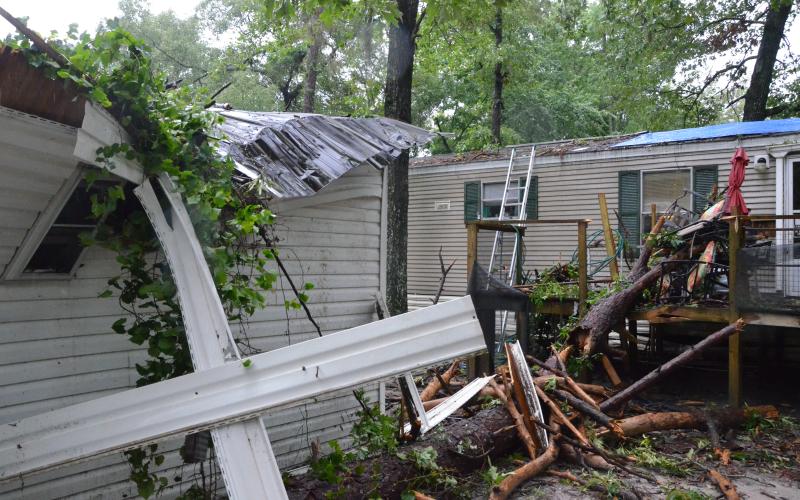 A local mobile home took a beating early Wednesday morning, after a storm rolled through the area and knocked a tree or two onto the structure. The residents took shelter in a bathroom, emerging shaken but safe. (CARL MCKINNEY/Lake City Reporter)