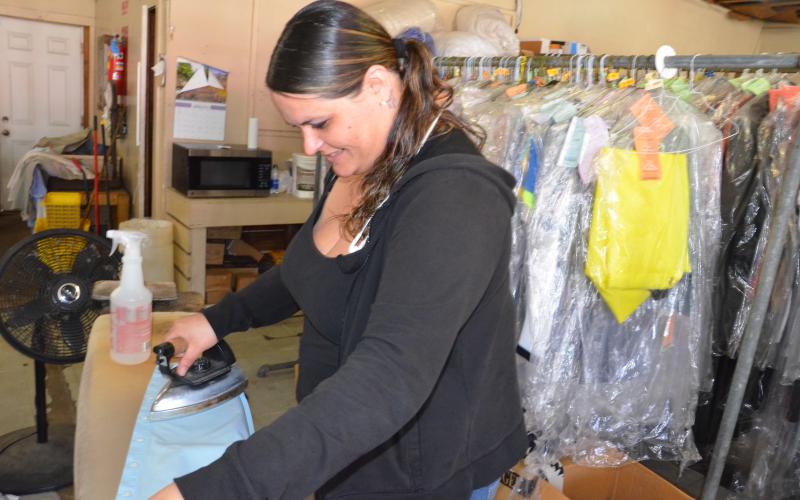 Katie Ceasar irons a shirt during a slow day at N&amp;W Cleaners on West Duval Street. (CARL MCKINNEY/Lake City Reporter)