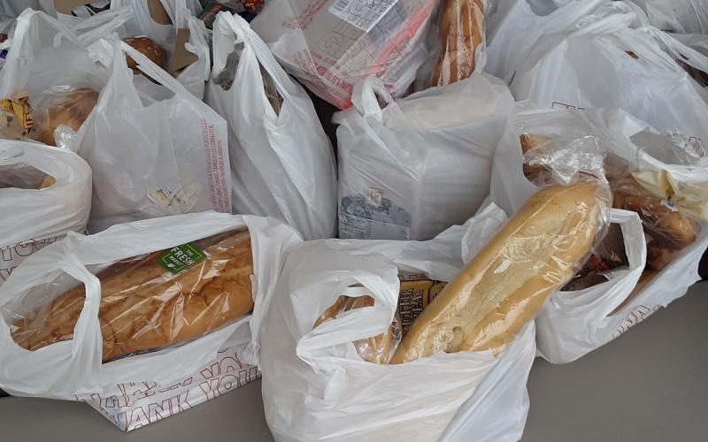 Bags containing bread and other food items await distribution at a local giveaway on Tuesday. The Worship Room, a new church founded in September, says it handed out roughly 40,000 pounds of food that day alone. (TOM NOTON/Special to the Reporter)