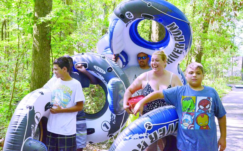 The Herrera family of Orlando walks down a trail toward the river in May 2016. Tubing season normally starts Memorial Day weekend. (CARL MCKINNEY/Lake City Reporter)