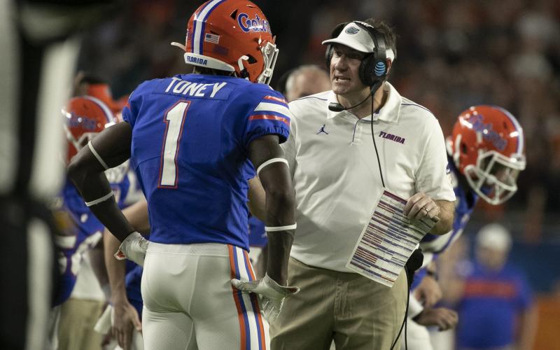 Florida head coach Dan Mullen, right, talks to Kadarius Toney during the Capital One Orange Bowl against Virginia at Hard Rock Stadium on Dec. 30, 2019, in Miami Gardens. (AL DIAZ/Miami Herald/TNS)