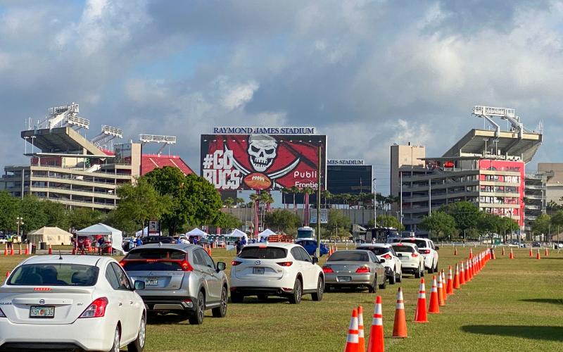 Cars are lined up in the parking lot outside of Raymond James Stadium for coronavirus testing on March 25, in Tampa. (LUIS SANTANA/Tampa Bay Times/TNS)