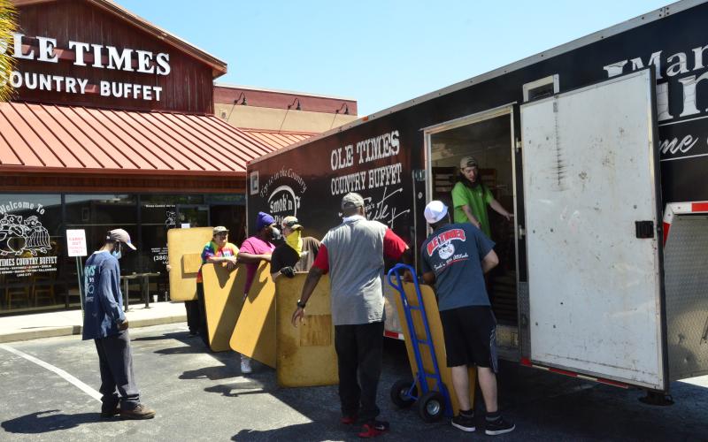 Employees at Ole Times Country Buffet move old furniture into a truck. The business says it made good use of the quarantine by remodeling, expecting patrons would appreciate the new look come next week. (CARL MCKINNEY/Lake City Reporter)