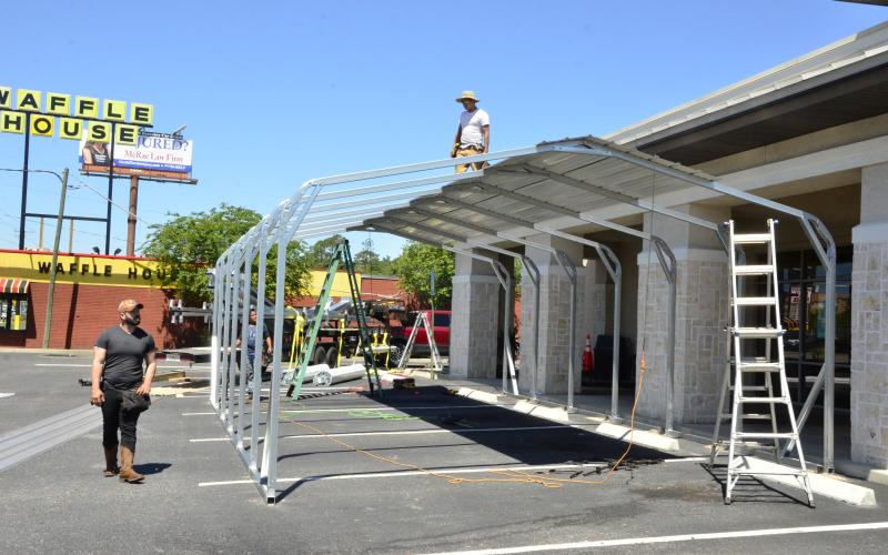 Workers construct an outdoor eating pavilion at Moe’s Southwest Grill, though the franchise’s marketing chief, Ferne Mann, balked a little when she heard a reporter describe the structure that way. “Boy, that’s a fancy name for a shed,” she said. The outdoor eating area will allow the restaurant to serve more dine-in patrons, offsetting restrictions on capacity that will be in place when Florida starts reopening on Monday. (CARL MCKINNEY/Lake City Reporter)