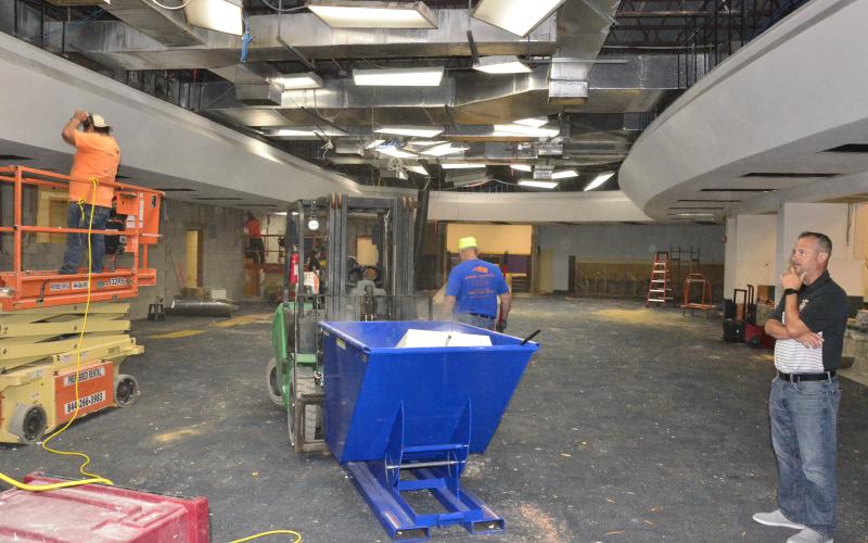 CHS Principal Trey Hosford checks out the progress construction workers have made on a project to remodel the library into a pair of learning labs. (CARL MCKINNEY/Lake City Reporter)