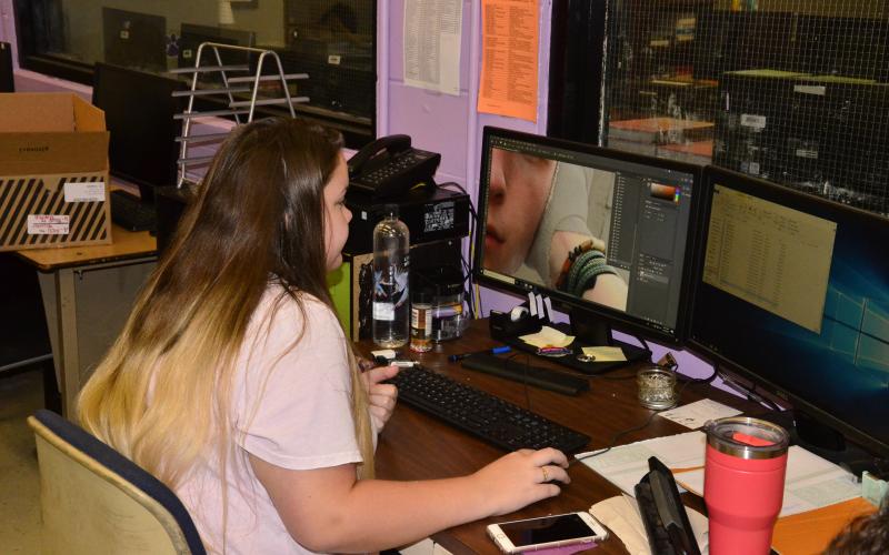 Photo editor Kelsey Wolcott edits a picture on a school computer. (CARL MCKINNEY/Lake City Reporter)