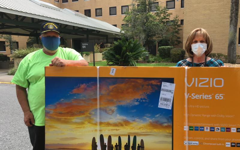 Michael Lydick, Lake City Elks Lodge #893 Veterans Committee chairman, stands with Cynthia Voltz of the Lake City VA Medical Center, as the two showoff a 65-inch television that was recently donated to the facility. The TV was one of several items donated for veterans who have been restricted from normal social outings due to the global pandemic. (COURTESY)